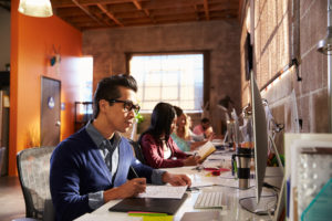 Designers Working At Desks In Modern Office